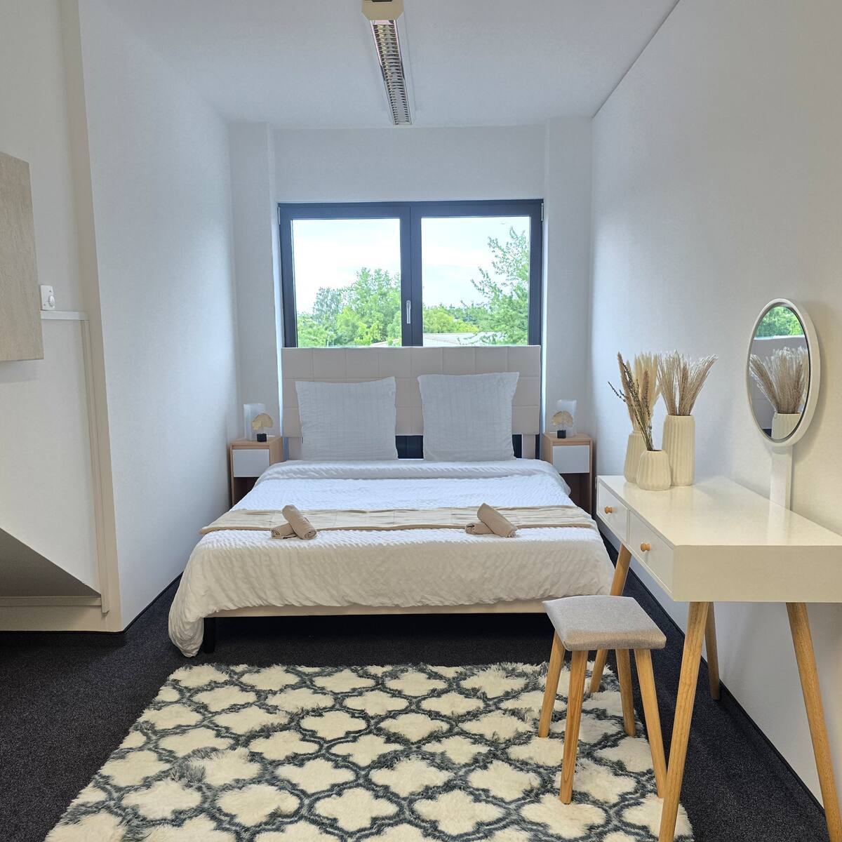 Schlafzimmer mit Doppelbett und Schminktisch in Lianbnb 1 in Ismaning